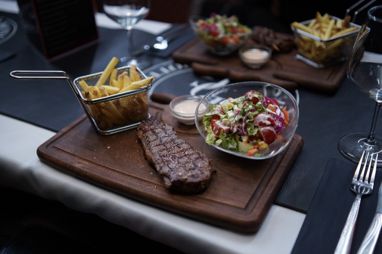 Entrecôte maturée grillée au charbon, frites maison et salade